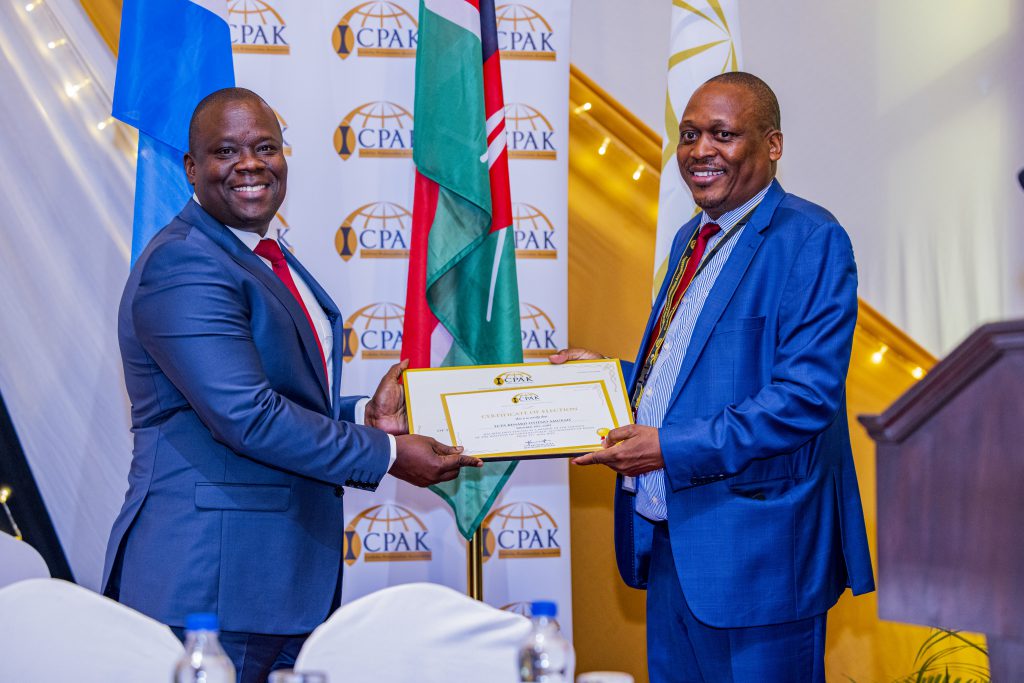 ICPAK council elections returning Officer CPA Kennedy Auka presenting a Certificate of Election to the new council member FCPA Benard Amukah.