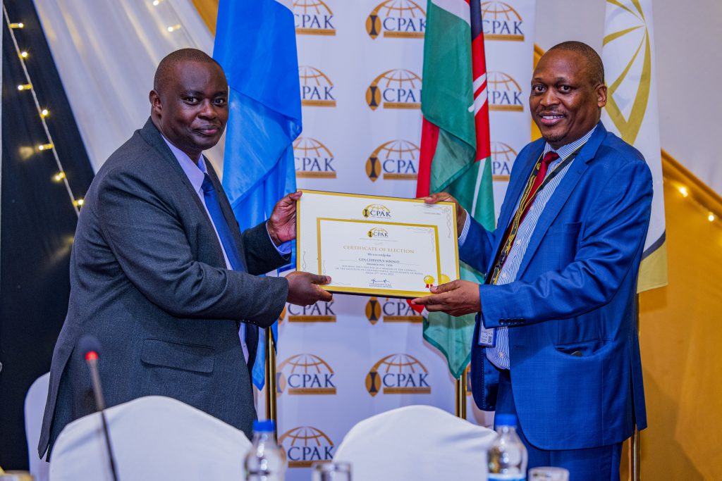 ICPAK council elections returning Officer CPA Kennedy Auka presenting a Certificate of Election to the new council member CPA Chrispus Mbogo.